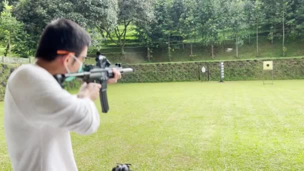アジア人射撃ライフル銃的的的的的射撃場屋外 — ストック動画