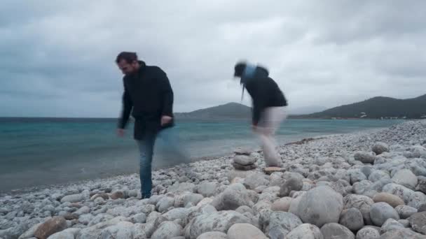 Φίλοι Που Αποτυγχάνουν Χτίσουν Ένα Πέτρινο Έλατο Μια Θυελλώδη Παραλία — Αρχείο Βίντεο