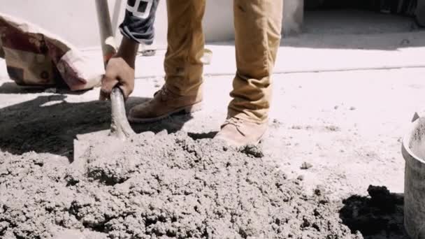 In Zeitlupe erschossen Arbeiter mit Schaufel sammelt Zement der Straße in Eimer im Freien bei Sonne