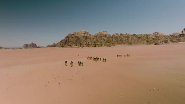 ヨルダンのワディ ラムに向かってアラビア砂漠でラクダに乗る観光客の空中ビュー — ストック動画