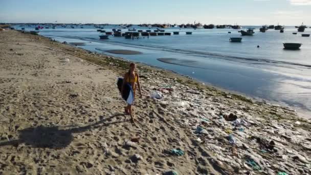 Жіночий Серфер Дошкою Серфінгу Проходить Через Купи Пластикових Сміття Пляжі — стокове відео
