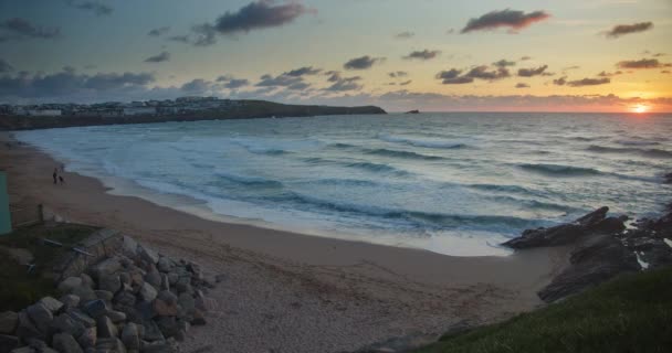 在英格兰康沃尔 人们带着狗在沙滩上嬉戏 波浪翻滚 地平线上的夕阳西下 固定射击 — 图库视频影像
