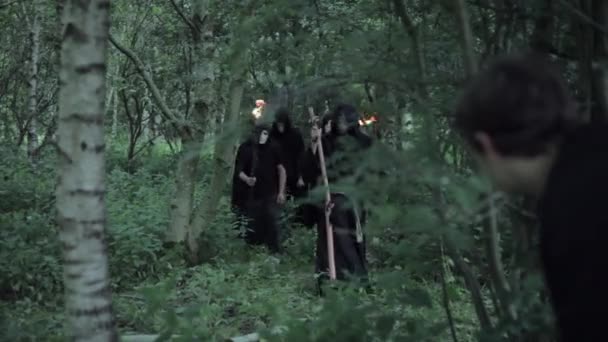 Nierozpoznawalny Człowiek Ukrywa Się Przed Kultem Złych Zakapturzonych Druidów Lesie — Wideo stockowe