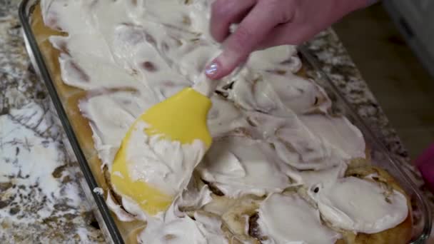 Spreading Cream Cheese Icing Freshly Baked Cinnamon Rolls — Vídeo de stock