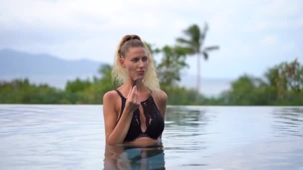 美丽的白种人游客在热带游泳池吃冰淇淋的相机前微笑 — 图库视频影像