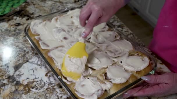 Spreading Cream Cheese Frosting Homemade Cinnamon Rolls — Vídeo de stock