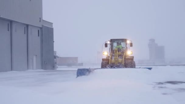 Sneeuwschuiver Trekker Ruimen Sneeuw Van Het Vliegveld Tijdens Sneeuwstorm — Stockvideo