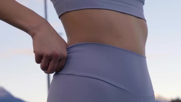 胃の周りのスポーツのレギンスを調整する女性 スローモーションの閉鎖 — ストック動画