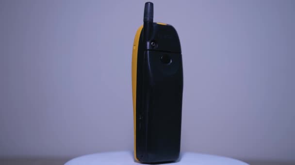 黄色诺基亚5110手机 外部天线在白色背景的转盘上旋转 靠近点 — 图库视频影像