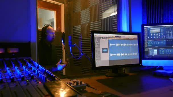 Ένας Άντρας Ηχογραφεί Μια Φωνή Ένα Στούντιο Ηχογράφησης Φωνητικού Θαλάμου — Αρχείο Βίντεο