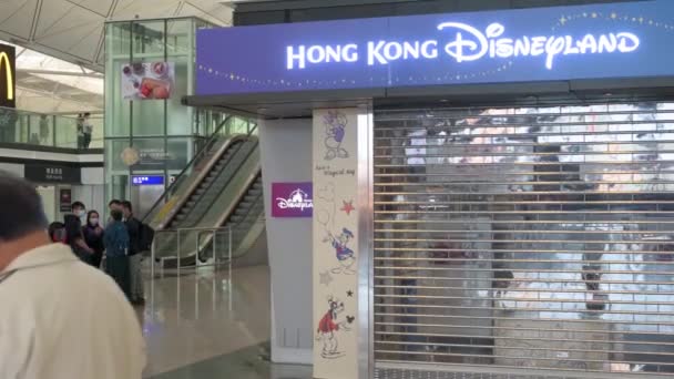 乗客は ほとんどの企業がCovid 19変異体の普及により閉鎖されているため 香港国際空港のディズニー公式テーマパークディズニーランド店を歩いてください — ストック動画
