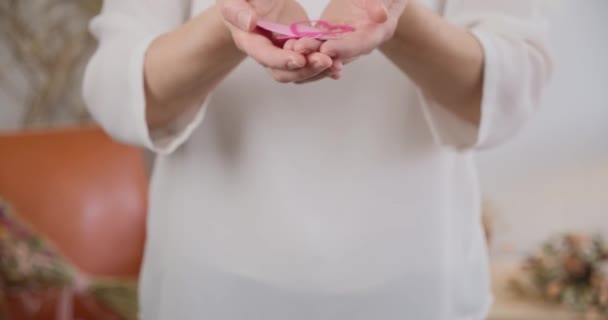 关闭静态拍摄的妇女杯手显示粉红的纸心 — 图库视频影像