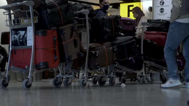 Σειρά Συσκευασμένων Αποσκευών Τρόλεϊ Αποσκευών Στο Αεροδρόμιο Χίθροου Χαμηλή Γωνία — Αρχείο Βίντεο