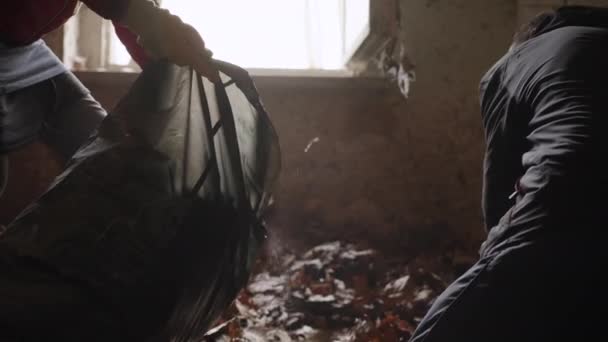 Workers Put Foliage Garbage Bag Dilapidated Room Slow Motion — Stok video