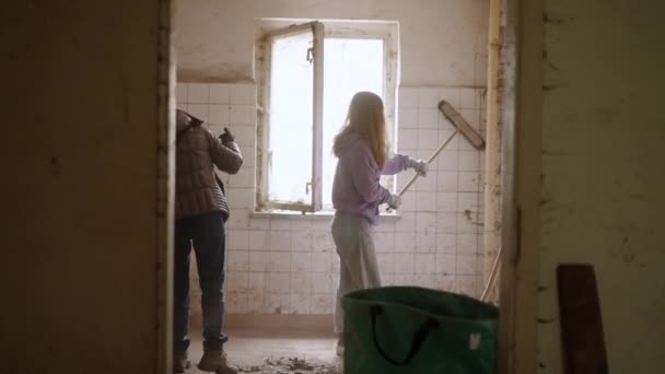 Twee Mensen Schoonmaken Van Een Oude Smerige Kamer Met Bezems — Stockvideo