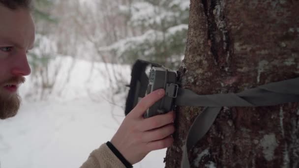 Mann Öffnet Und Fixiert Winter Die Camouflage Trail Kamera Einem — Stockvideo