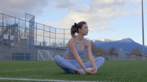 Woman Doing Butterfly Stretch Grass Sports Field Slowmo — Video Stock