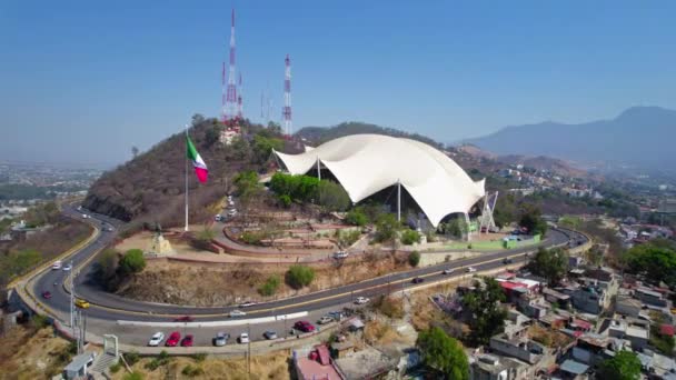 教科文组织 墨西哥瓦哈卡市 著名的Guelaguetza礼堂大楼旁边的墨西哥山顶国旗空中俯瞰 — 图库视频影像