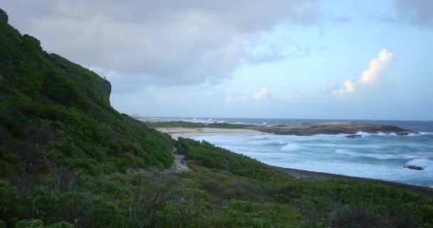 巨大的蓝色波浪与游客一起冲向海滩 在通往海滩的青山边的小径上远足 — 图库视频影像