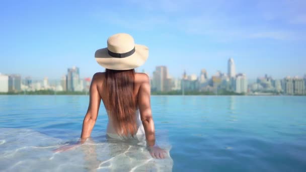 Back Camera Woman Sun Hat Sits Step Resort Pool She — Vídeo de Stock