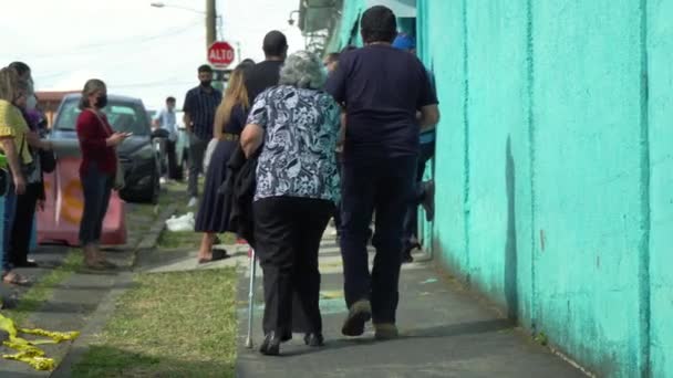 圣乔斯 科斯塔里卡 2022年2月6日 选举日社论 一个男人带着一位老太太站在投票站外排队 人们排队 后空翻 — 图库视频影像