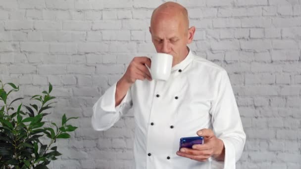 Ein Älterer Chefkoch Macht Eine Pause Der Küche Und Telefoniert — Stockvideo