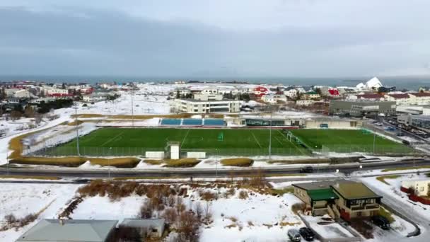 冰岛雷克雅未克的足球场冬季被住宅环绕 空中升空 — 图库视频影像