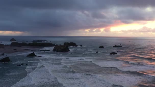 オレゴン海岸は 海の岩の上に嵐の雲と劇的な日没 果てしなく続く海のうねりが — ストック動画