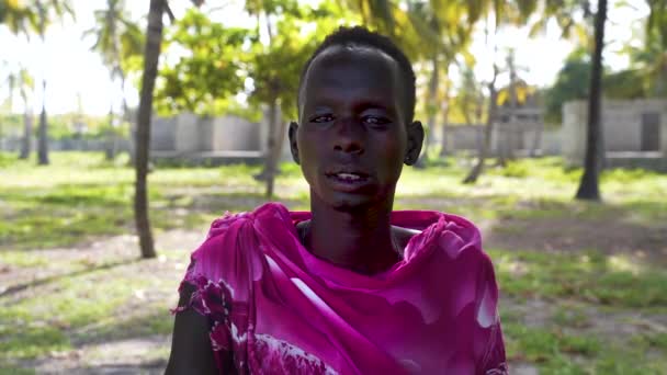 Massai Mann Pinkfarbener Kleidung Palmenhain Seinem Dorf Dahinter — Stockvideo
