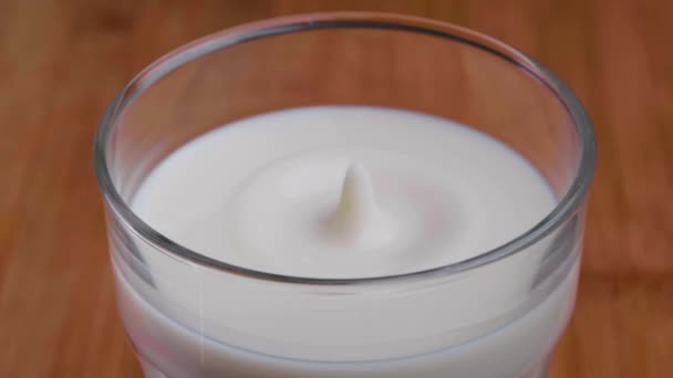 Cámara Lenta Una Gota Leche Salpicando Vaso Leche Sobre Una — Vídeos de Stock