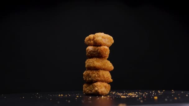 一堆堆烹调精美的素食 金黄色鸡块在黑色背景下旋转 静止射击 — 图库视频影像