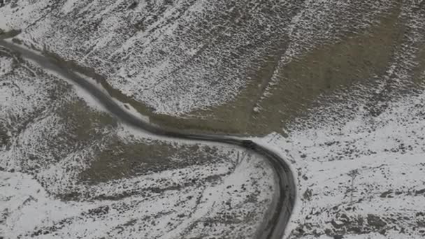 雪と路上で車の空中ショット側に山のキャップ パキスタンのギルギット バルティスタン州ハンザ バレーにあるクンジャラブ国立公園を通ってカラコルム ハイウェイ — ストック動画