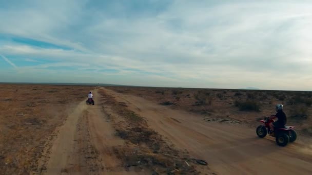 Riding Three Wheelers Dirt Road Mojave Desert Aerial Follow Slow — стоковое видео