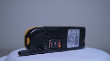 Beyaz arkaplanda dönen sarı vintage Nokia gsm cep telefonu aygıtı