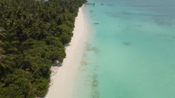 无人机飞越了马尔代夫岛的海岸 蓝色的海水映衬着美丽的天空和水中的一个码头 — 图库视频影像