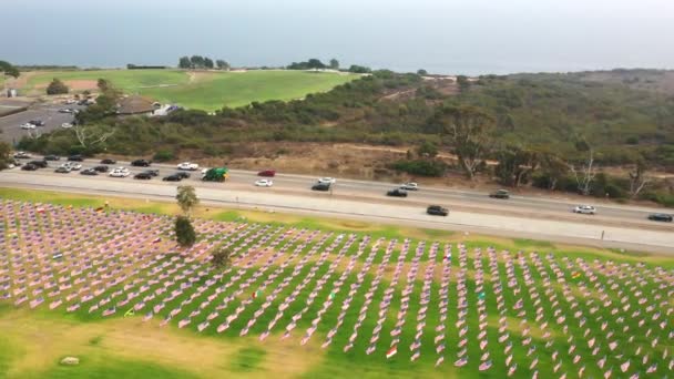 カリフォルニア州マリブで9月11日の攻撃を祝う旗を振ってペパーディン大学の卒業生公園に沿って交通 空中ワイドショット — ストック動画