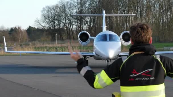 Trabalhador Aeroporto Direcionando Learjet Para Seu Terminal Chegada Para Que — Vídeo de Stock