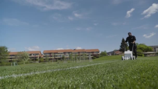 Man Met Hoed Trekt Lijn Met Witte Verf Gras Voetbalveld — Stockvideo