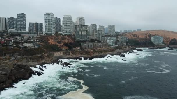 Aerial Dolly Sea Waves Hitting Rocky Hillside Shore Concon Apartments — Stock Video