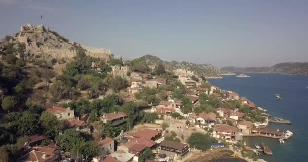 飞越卡斯市上空 卡斯市从空中传来 土耳其的一个小港口 漂亮的土耳其海湾 从房子上空飞向国旗 城堡在顶部 美丽的风景 — 图库视频影像