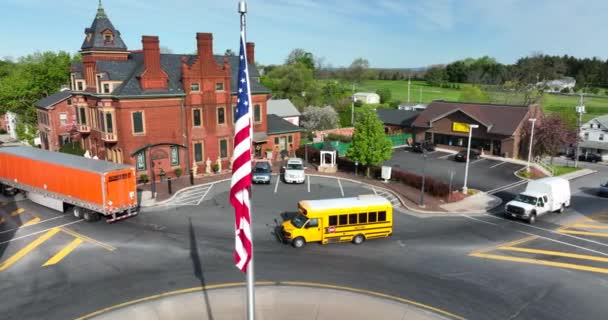 Krótki Autobus Szkolny Przejeżdża Przez Centrum Small Town America Flagą — Wideo stockowe