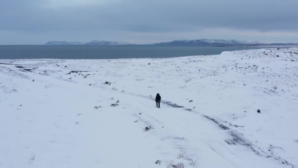 Mann Geht Auf Küstenklippen Weißer Schneebedeckter Landschaft Antenne — Stockvideo