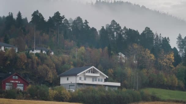 農村ノルウェーの秋 整頓された家や緑の芝生 薄い霧が土地の上にかかっている スローモーション パン左 — ストック動画