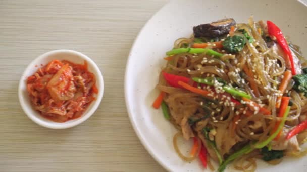 白ゴマの上に野菜と豚肉をのせた日本風または炒め物の韓国の春雨麺 韓国の伝統料理 — ストック動画