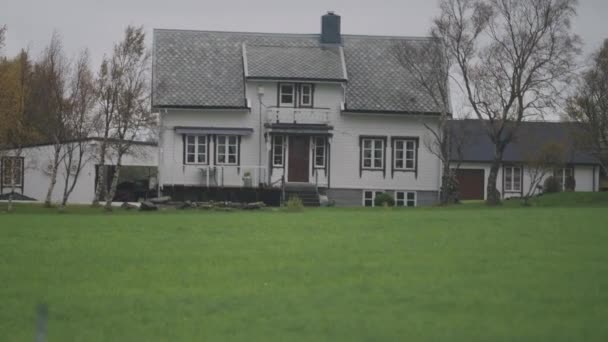 挪威农村的一个农舍 附近的谷仓和其他建筑物 翠绿的草坪和无叶的树 慢动作 — 图库视频影像