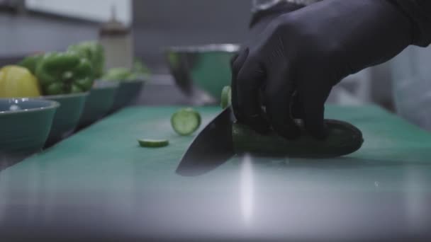 Szef Kuchni Kroi Ogórka Pomocą Noża Czarnymi Rękawiczkami Zielonej Desce — Wideo stockowe
