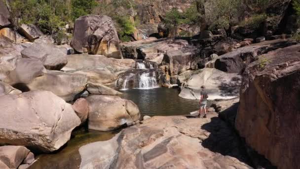 Man Met Australische Outback Hoed Loopt Naar Waterval Toerisme Wandelconcept — Stockvideo