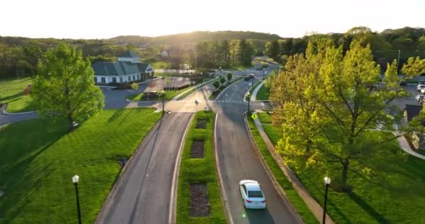 Flygspårning Vit Bil Förort Närmar Sig Trafikljuskorsningen Gyllene Timmen Ljus — Stockvideo