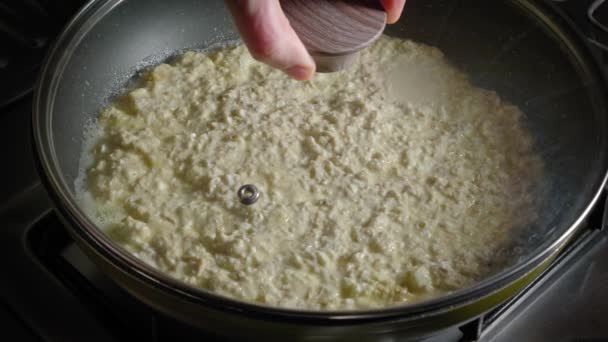 Covering Pan Glass Lid While Cooking Oatmeal Cheese Dinner Close — Vídeos de Stock