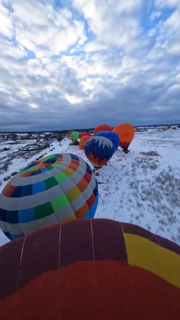 寒い冬の日にカラフルな熱気球パラシュートの垂直Fpv 4K空中ビュー離陸準備 ダイナミックドローンショット — ストック動画